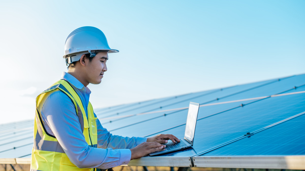 Un jeune professionnel consulte un logiciel lui permettant de suivre la production des panneaux solaires. 